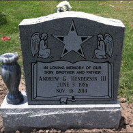 A grey granite headstone for Andrew G. Henderson III, featuring an engraved star, two angels, and dates of 1986–2014.