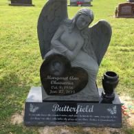 A gray angel headstone for Margaret Ann Chavarria (1956–2015) with the family name Butterfield on a black granite base.