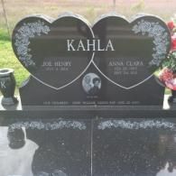 A black polished granite tombstone featuring two connected heart-shaped carvings with the name KAHLA engraved on top.