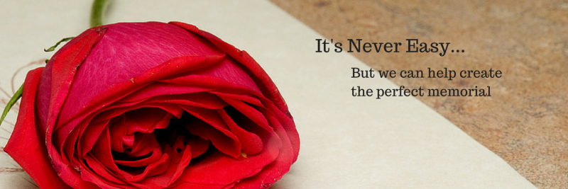 A red rose lies on a pale surface next to the text 