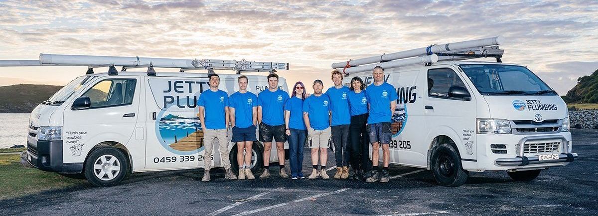 The Jetty Plumbing team standing outside their work vehicles in Coffs Harbour