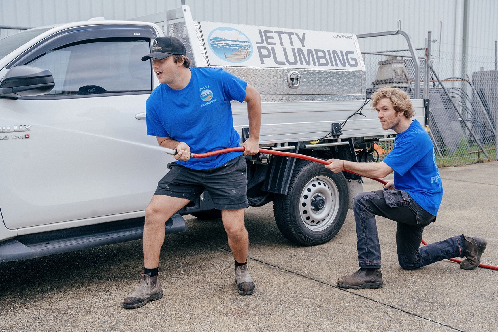 Two team members at Jetty Plumbing holding a hose ready for any issues