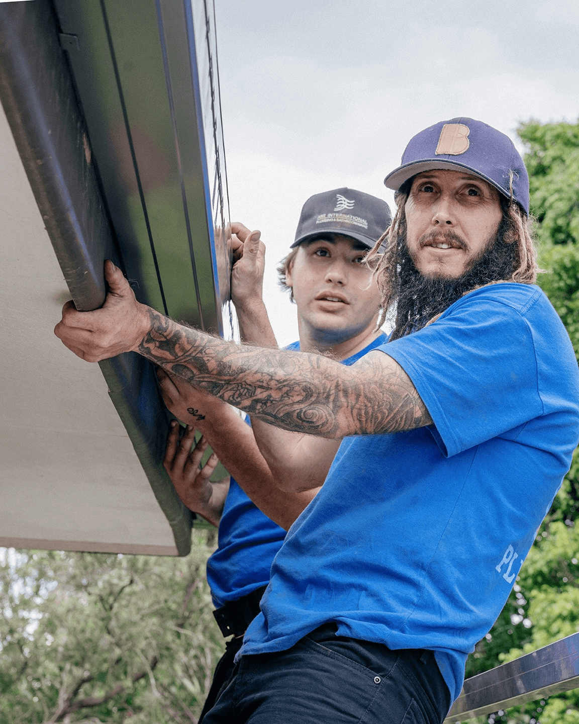 2 men from Jetty Plumbing replacing guttering on a roof