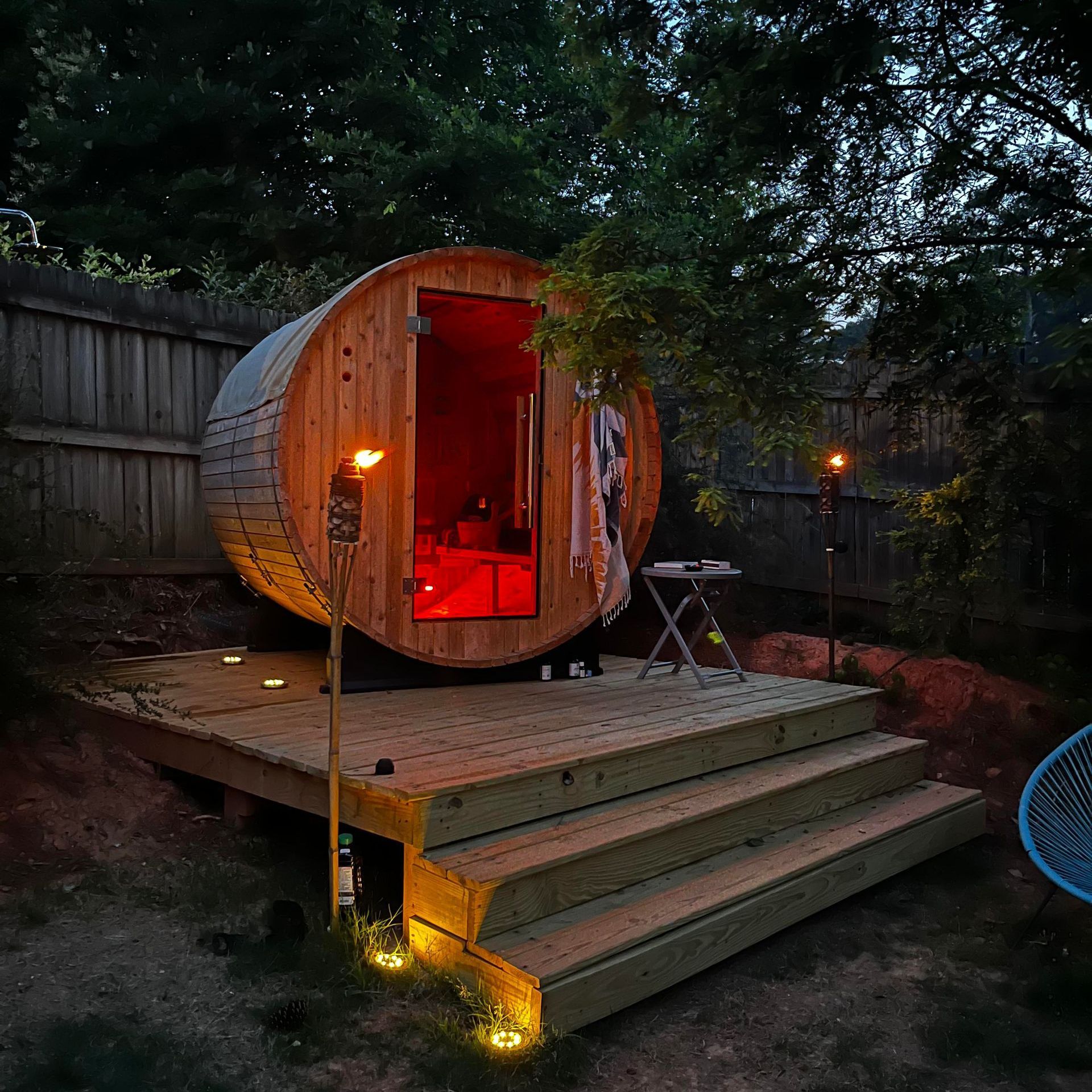 a wooden barrel shaped sauna is lit up at night