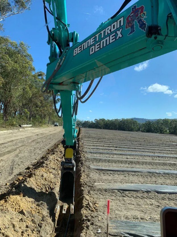A Green Excavator is Digging a Hole in the Ground — Bennettron Demex in Corindi Beach, NSW