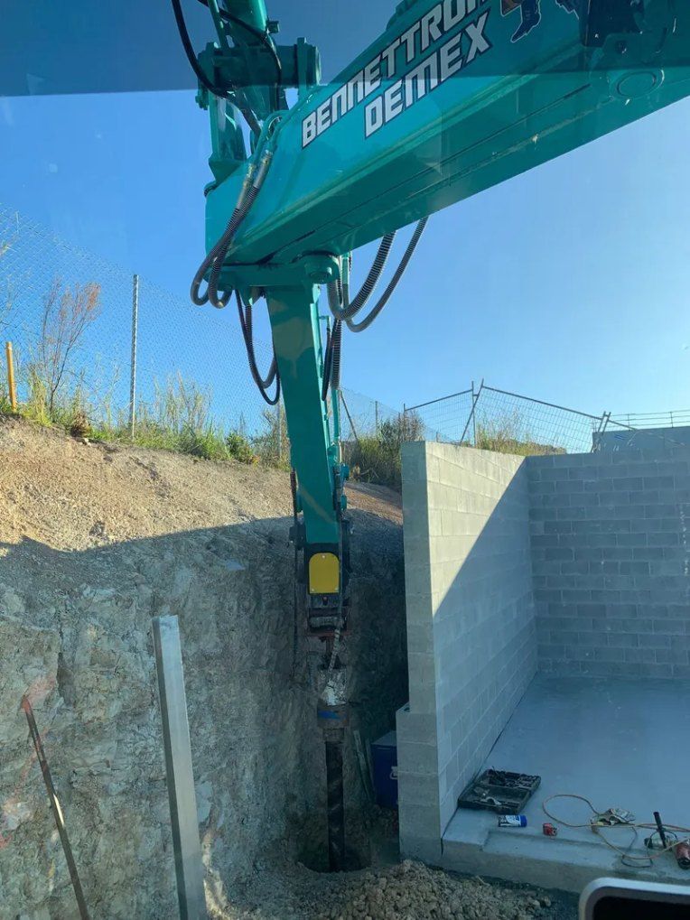 A Large Green Crane is Sitting in the Dirt Next to a Brick Wall — Bennettron Demex in Corindi Beach, NSW