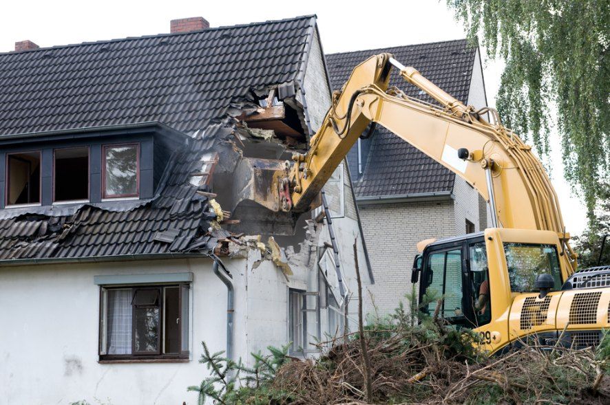 A Yellow Excavator is Demolishing a House — Bennettron Demex in Nambucca Heads, NSW
