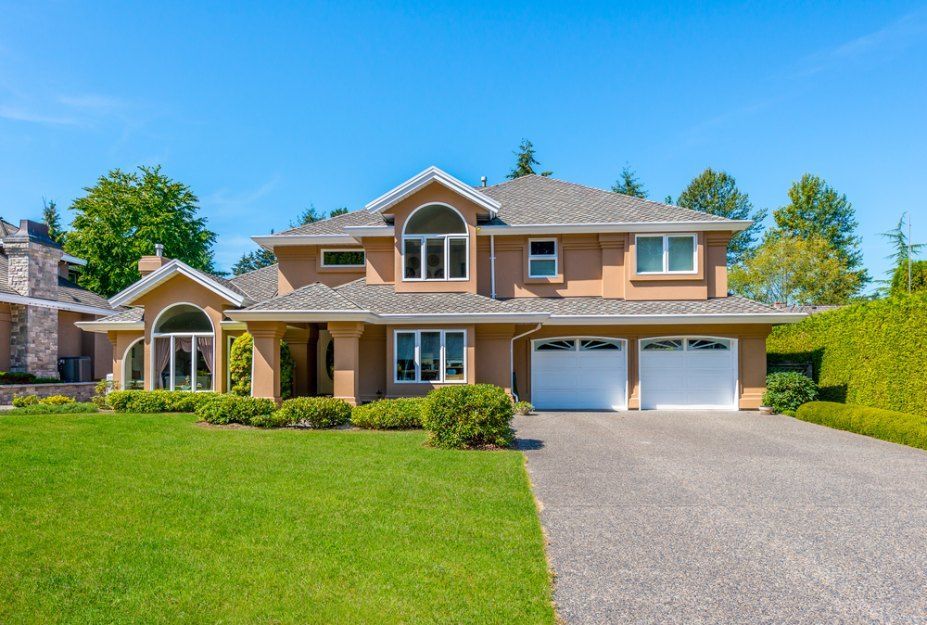 A large house with two garages and a lush green lawn — Bennettron Demex in Corindi Beach, NSW