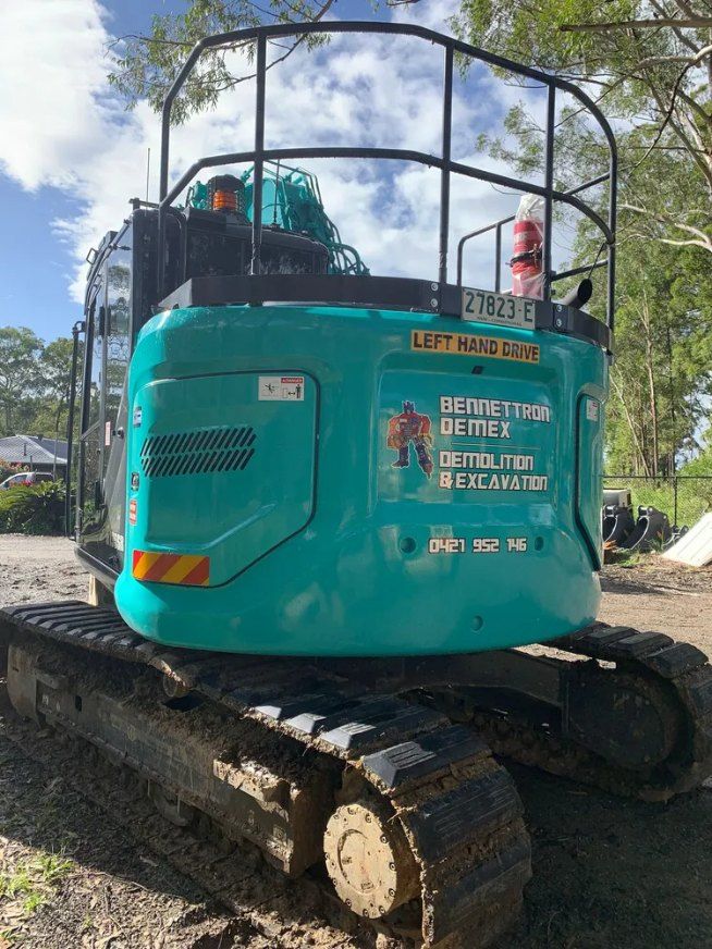 A Blue Excavator is Parked on the Side of a Dirt Road — Bennettron Demex in Mullumbimby, NSW