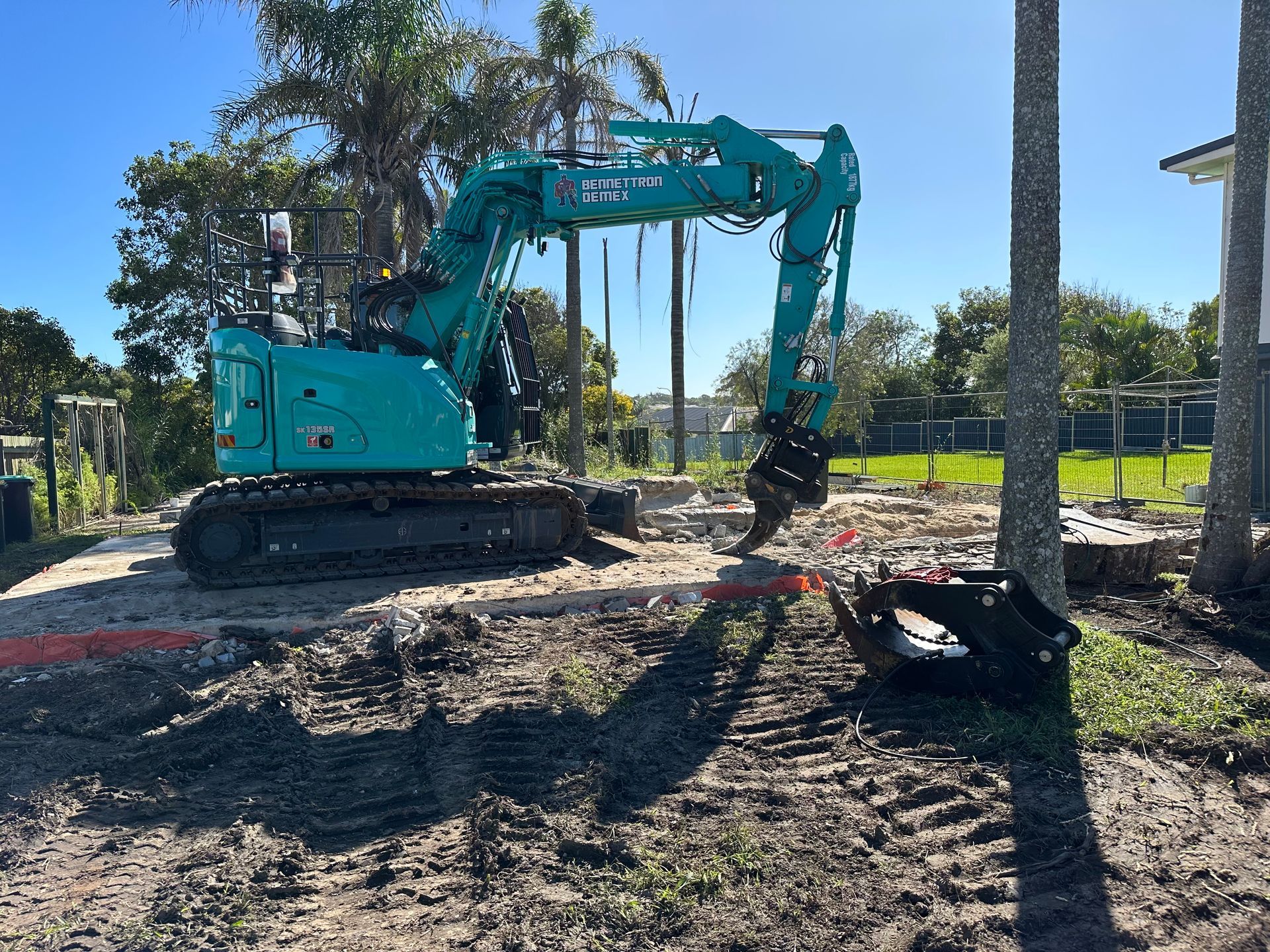 A Large blue Digger is on lawn  — Bennettron Demex in Corindi Beach, NSW