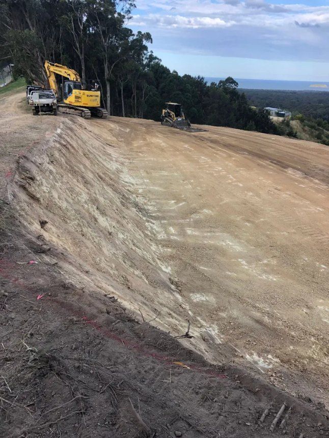 A Yellow Excavator is Sitting on Top of a Dirt Hill — Bennettron Demex in Port Macquarie, NSW