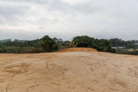 A Dirt Field With Trees in the Background and a Cloudy Sky — Bennettron Demex in Wooli, NSW