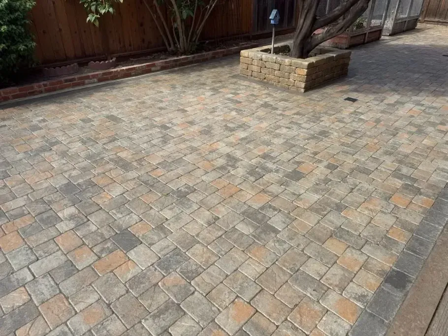 Paved stone patio with a planter box and wooden fence along the edge