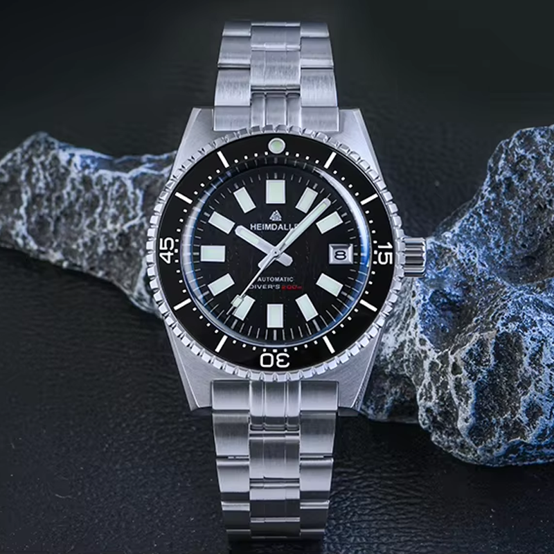 A silver and black watch is sitting on top of a rock.
