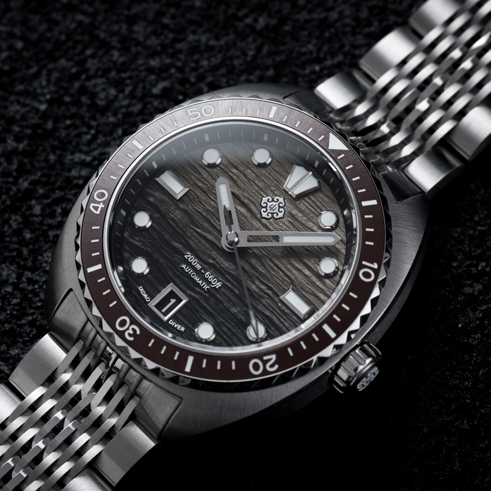 A close up of a watch with a stainless steel band