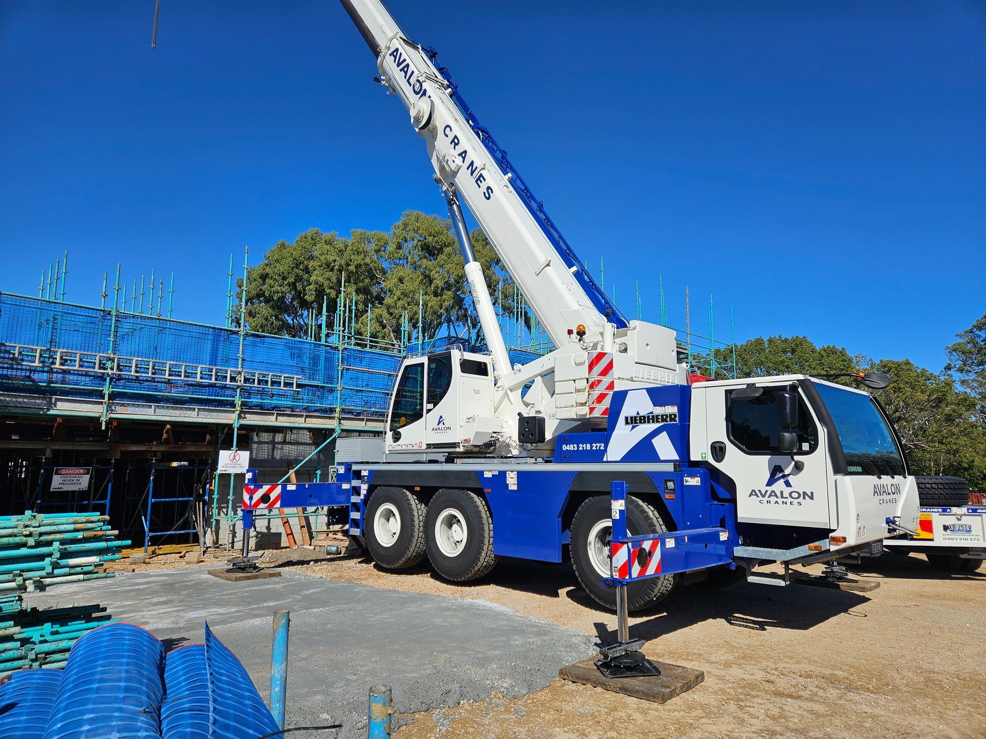 A large yellow crane is parked in front of a building