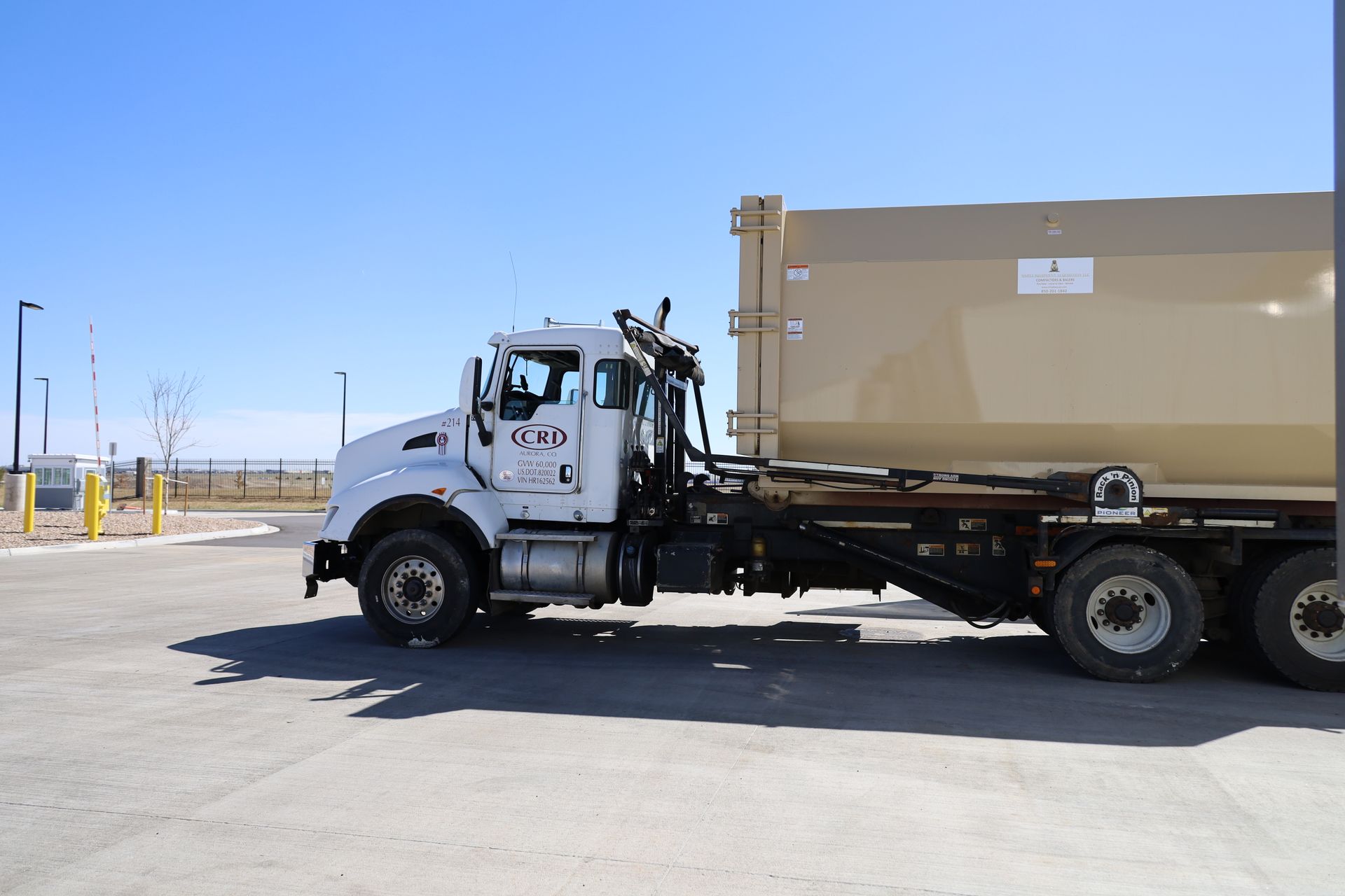 A garbage truck is parked in front of a building filled with garbage - Aurora, CO - Curbside Roll-Off