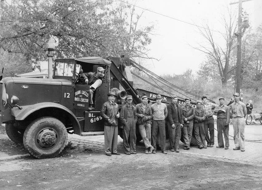 A Group of Men Are Standing in Front of a Tow Truck — Akron, OH — Frank Lucco Company