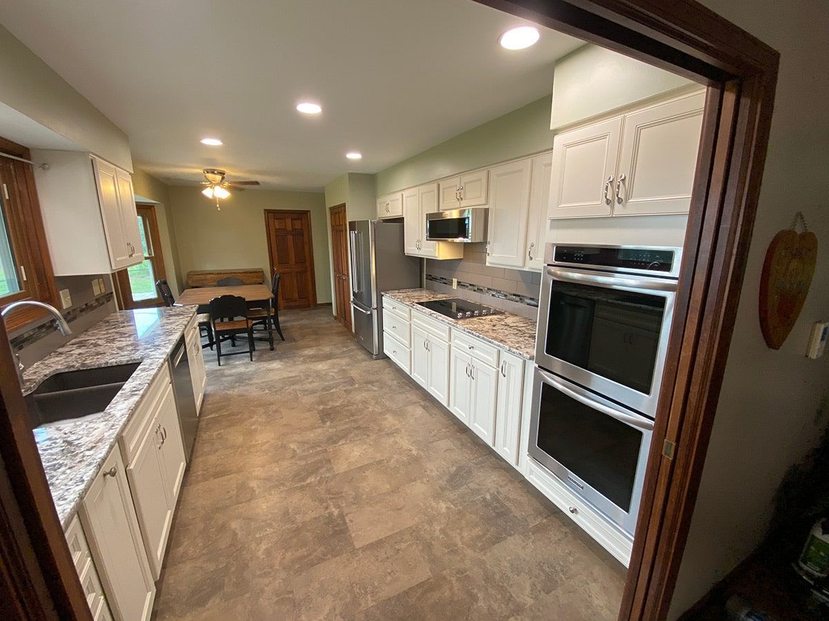 a kitchen with white cabinets and stainless steel appliances .