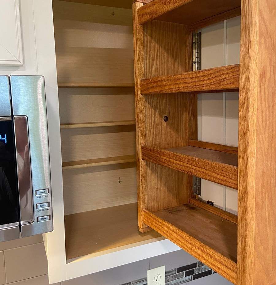 a stainless steel microwave sits next to a wooden cabinet