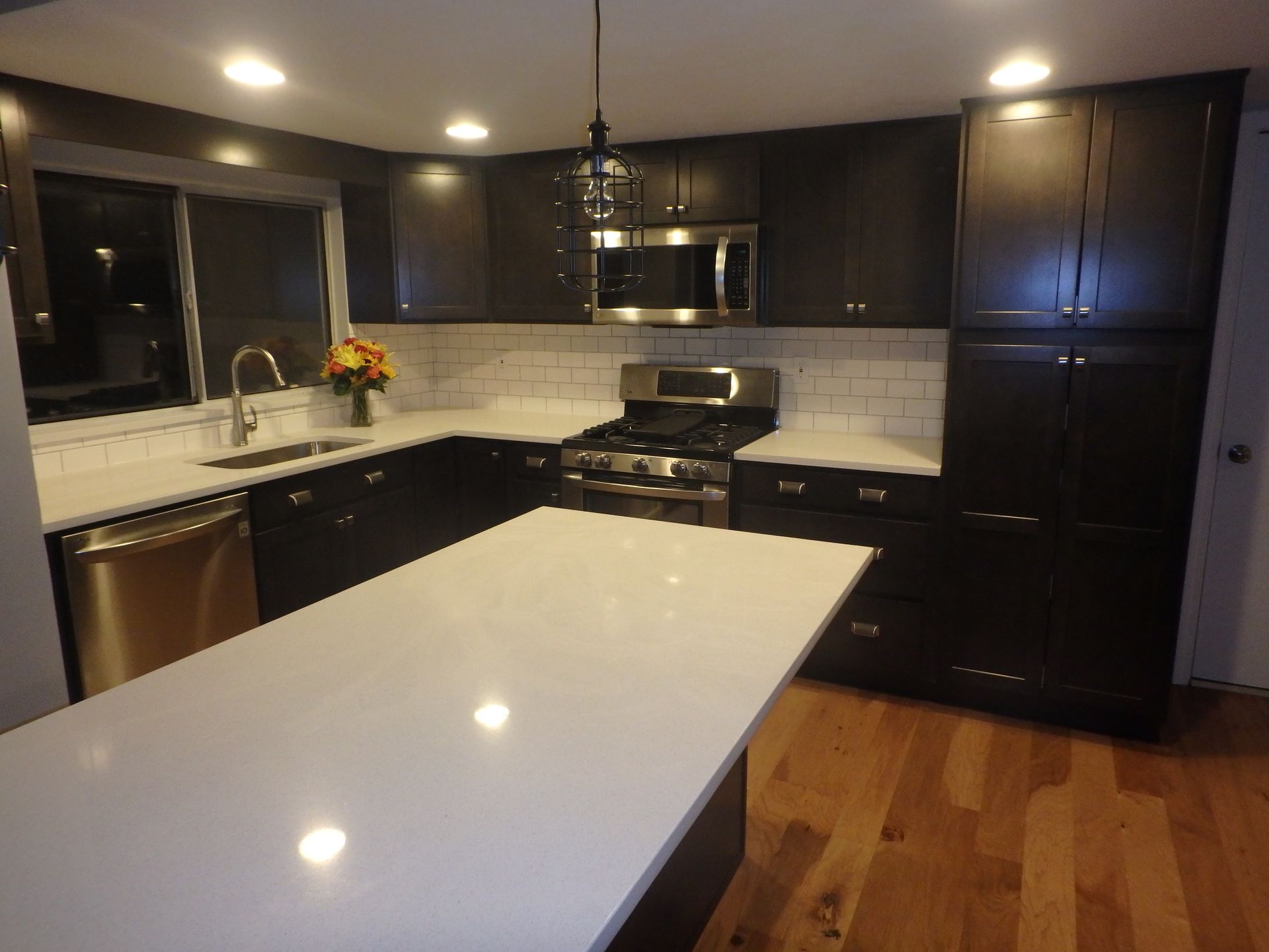 a kitchen with black cabinets and white counter tops