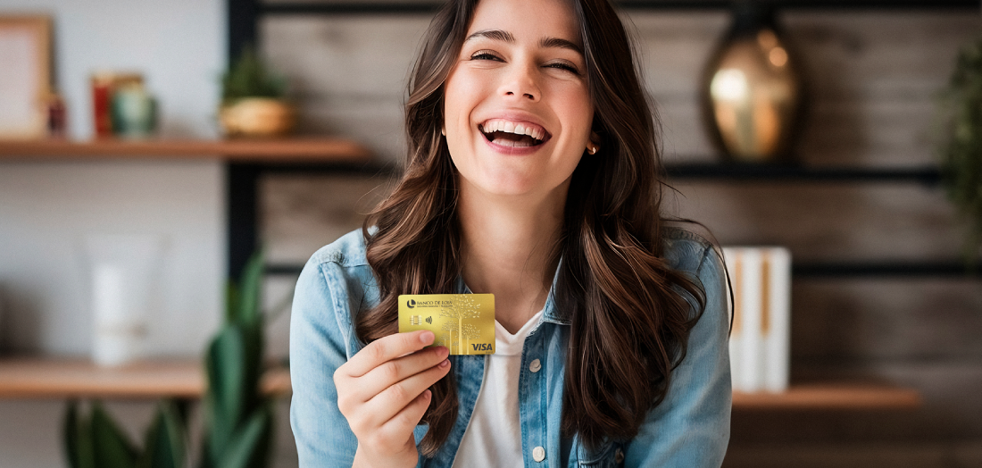 Una mujer sostiene una tarjeta de crédito y un teléfono celular.