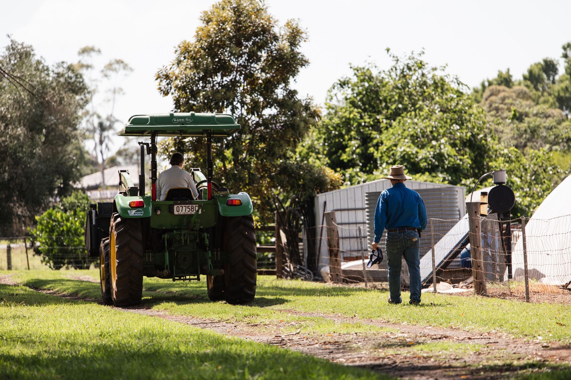 Downlands student on a tractor with a teacher walking alongside on foot. 