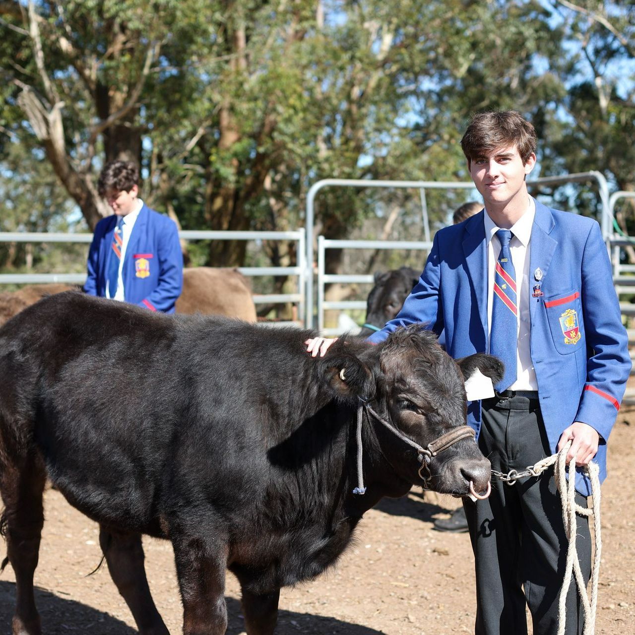 Downlands agriculture student smiling, standing in front of the agriculture garden beds. 