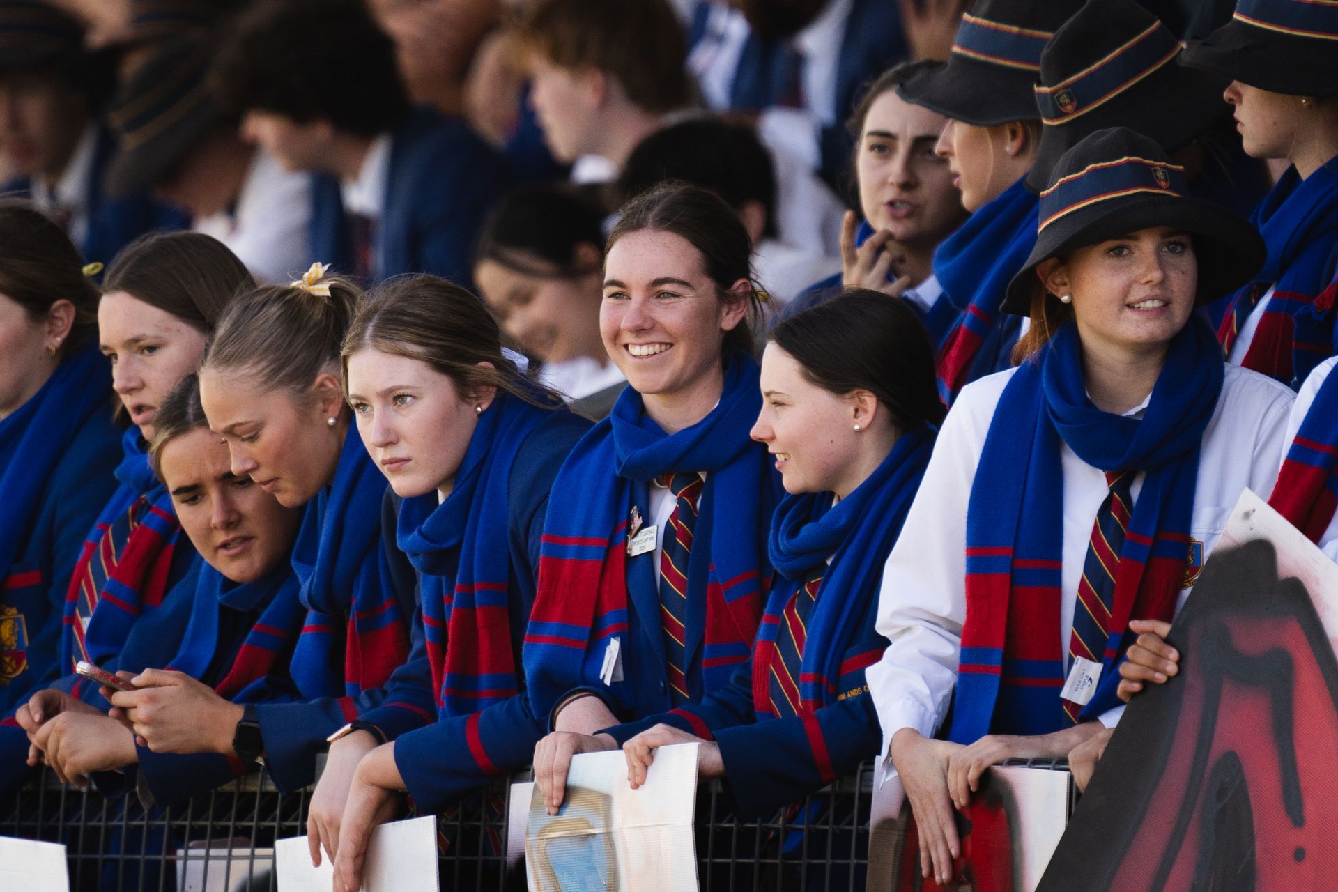 Students in the grandstands supporting a rugby match. 