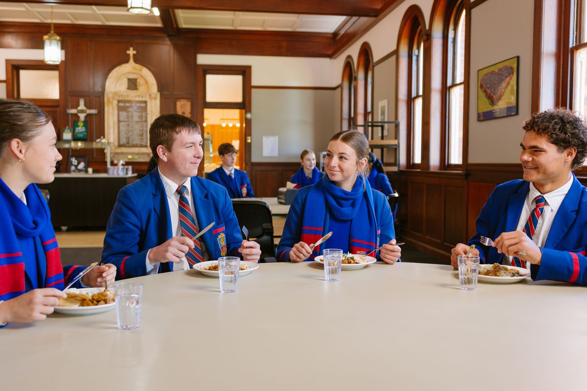 Students eating their dinner at a table. 