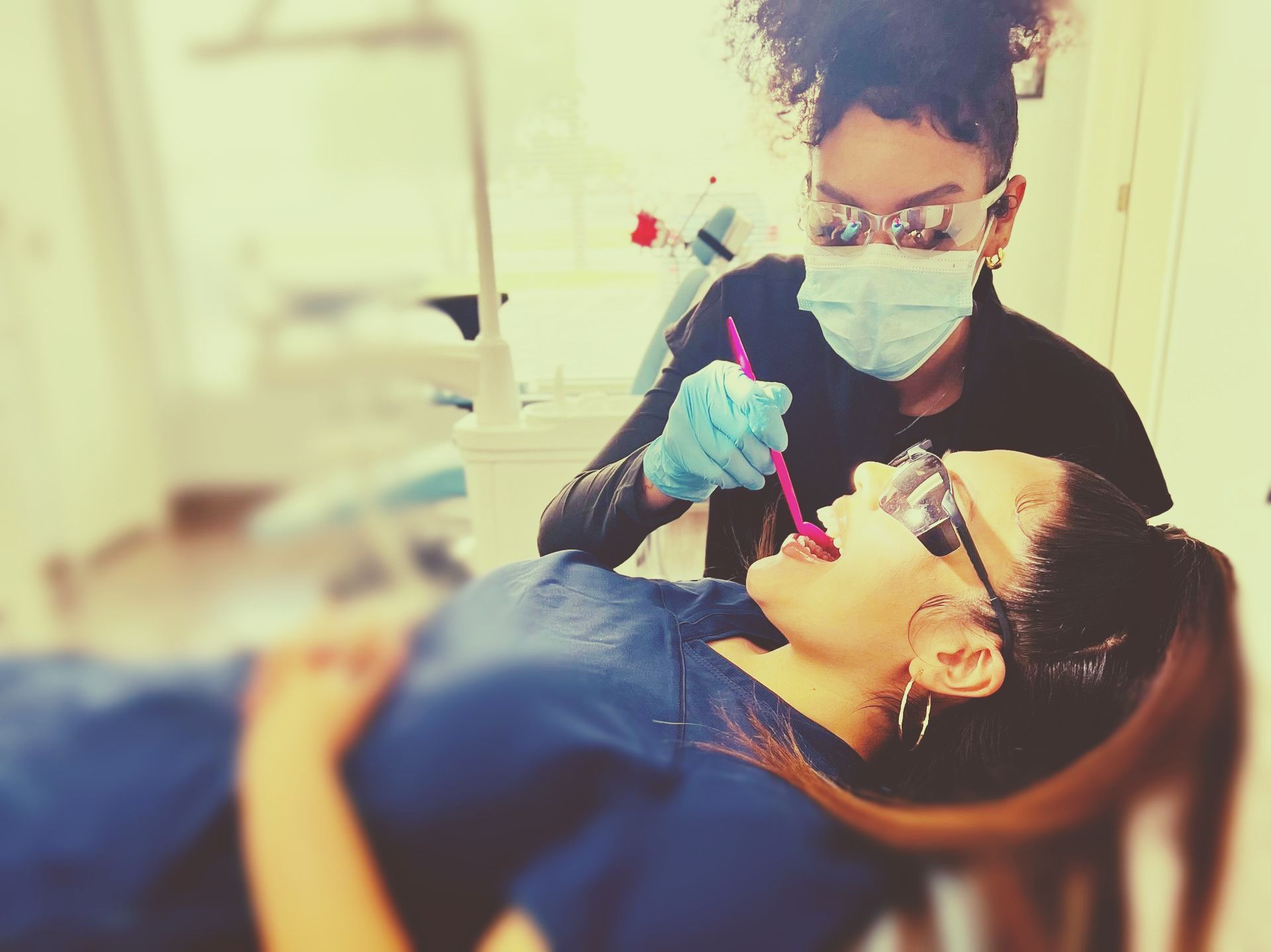Dental assistant assisiting patient, working intraorally.