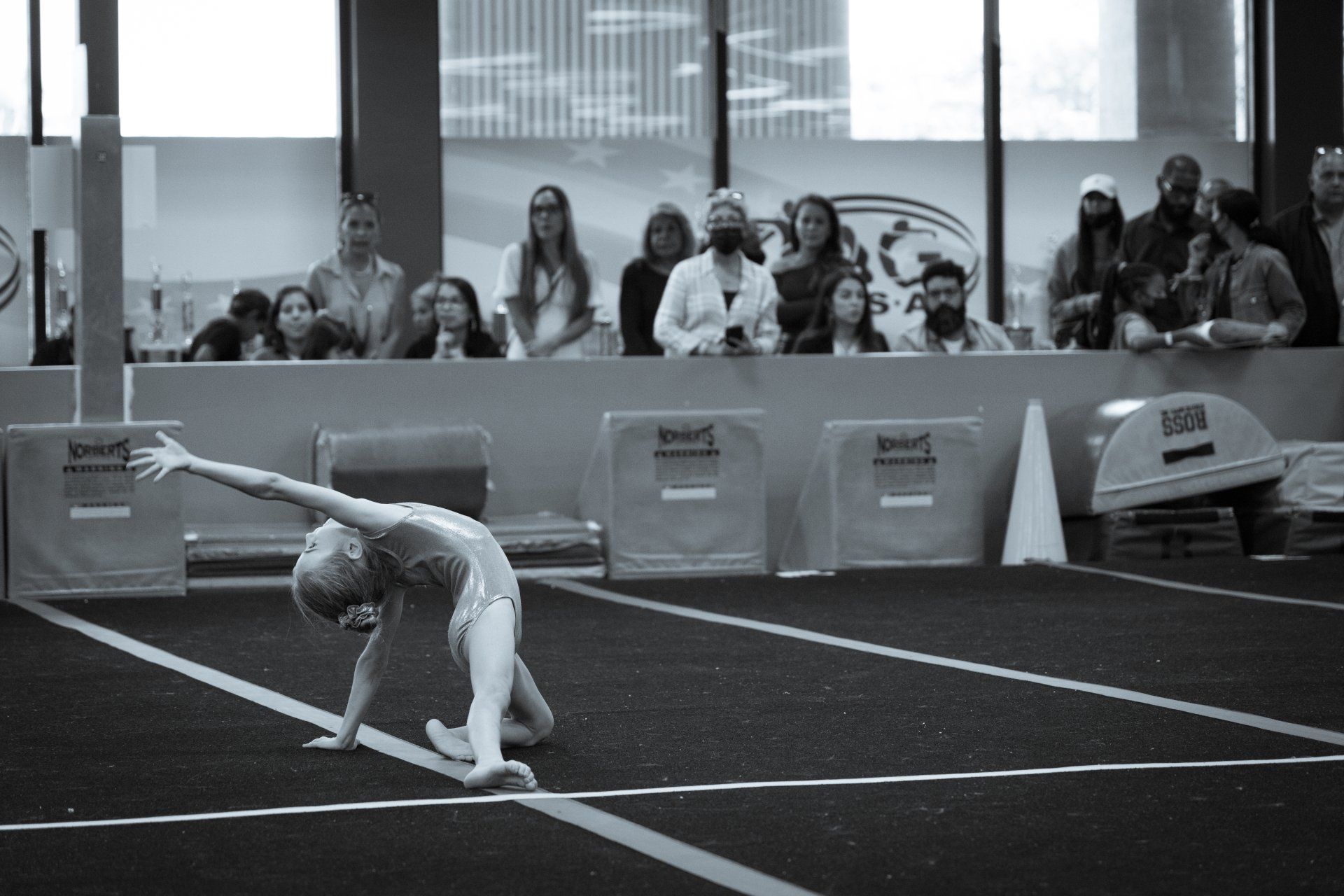 A black and white photo of a gymnast doing a handstand