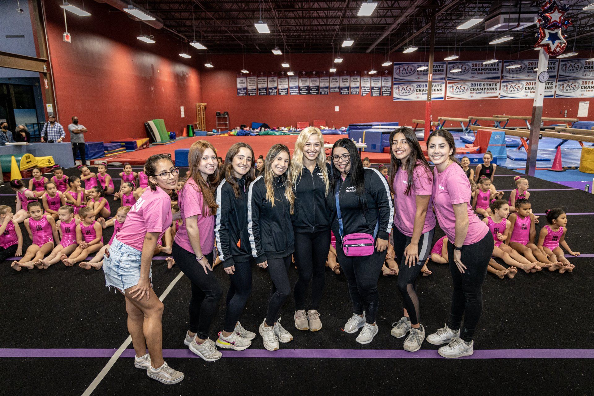 A group of women are posing for a picture in a gym.