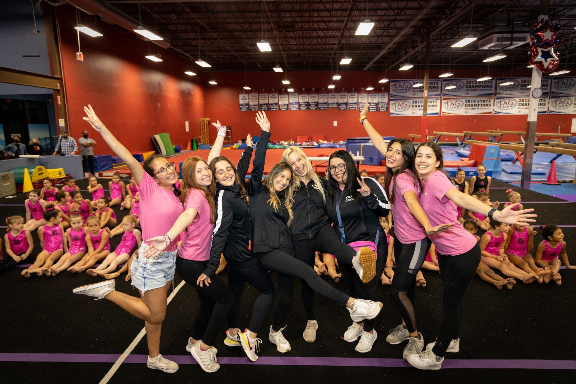 A group of girls are posing for a picture in a gym.
