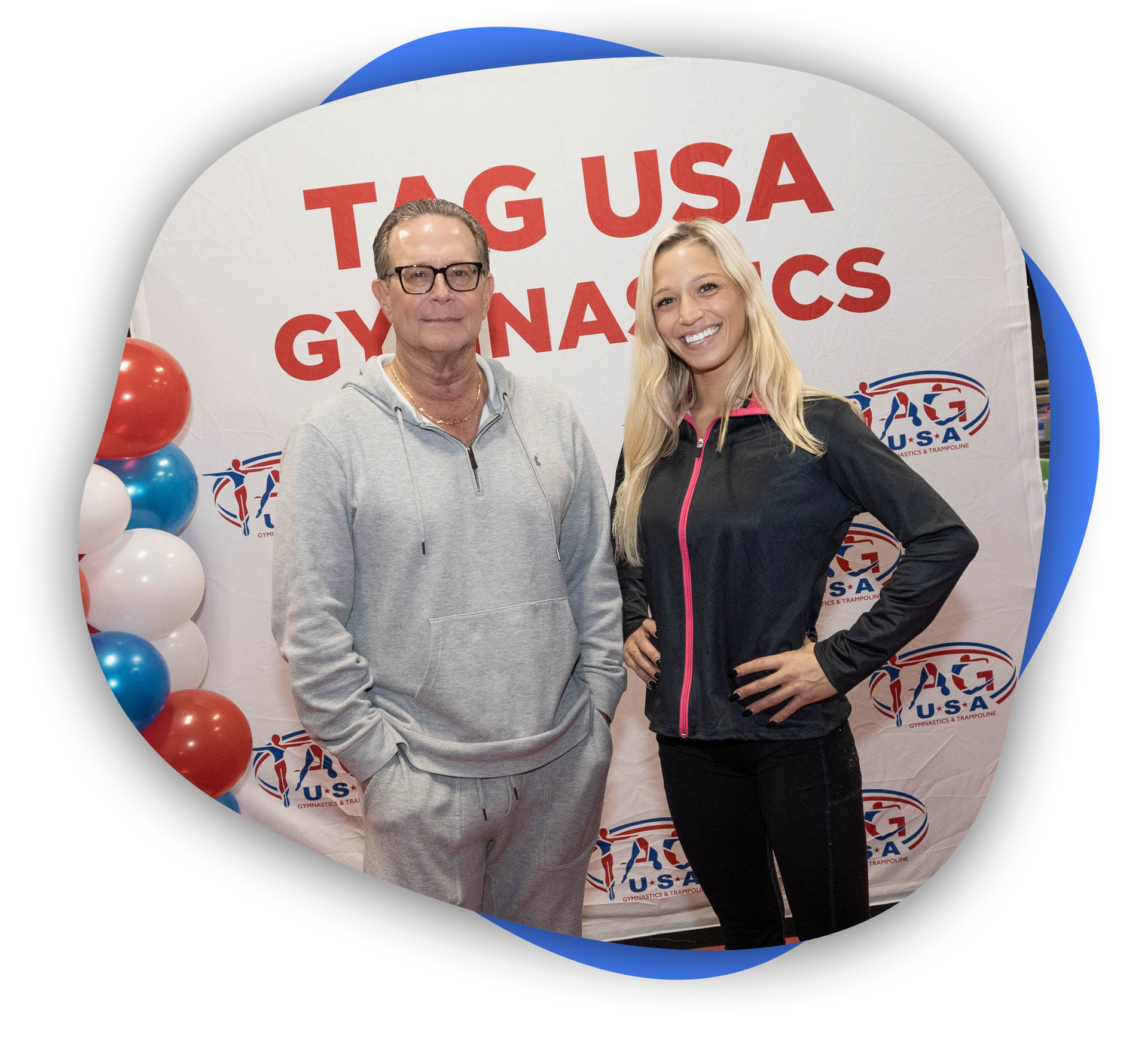 A man is smiling in front of an american flag and the logo for tag usa gymnastics and trampoline