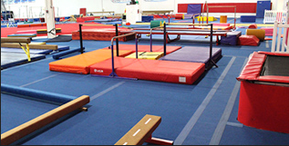 A gym with a trampoline and a balance beam