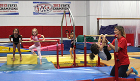 A group of young girls are doing gymnastics in a gym.