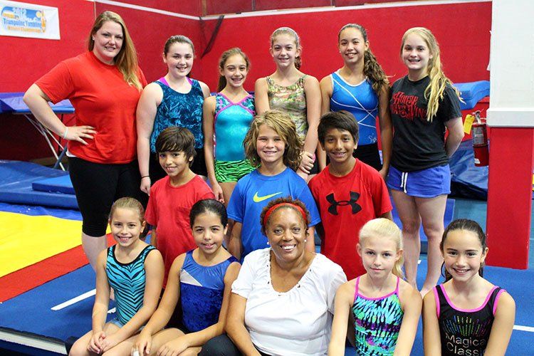 A group of young girls are posing for a picture in a gym.