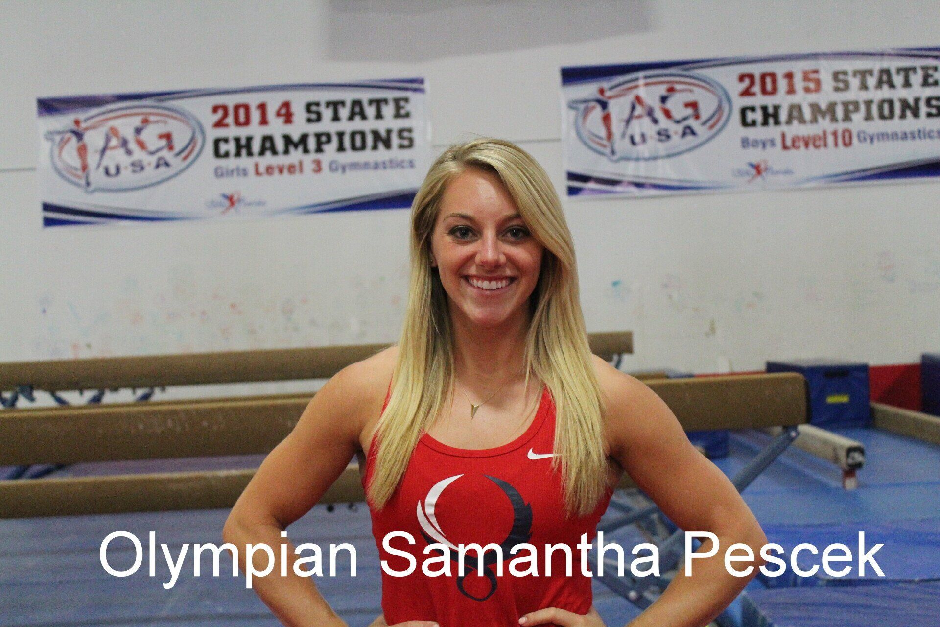 A woman in a red tank top is standing in front of a sign that says 2014 state champions