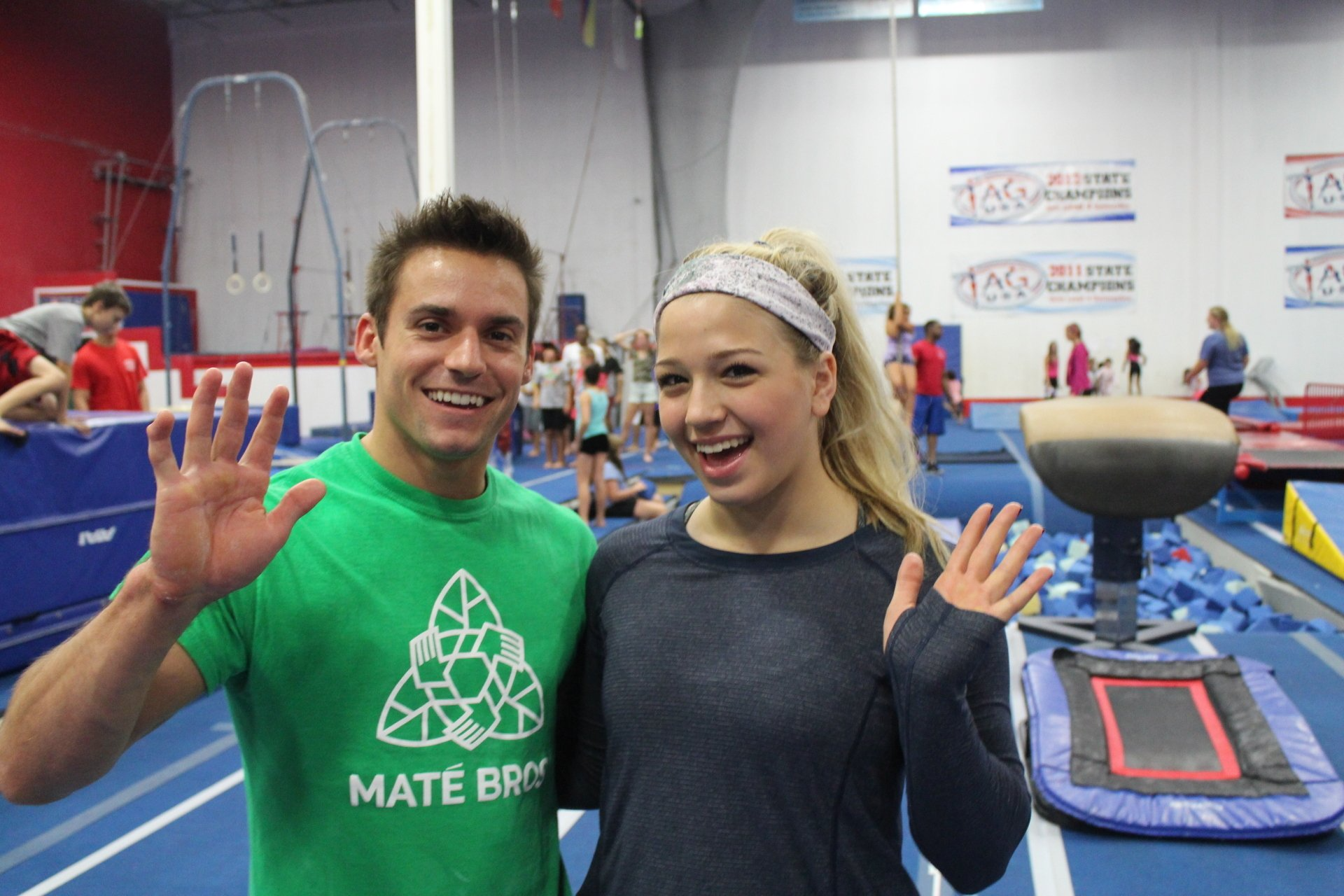 A man and a woman are posing for a picture in a gym.
