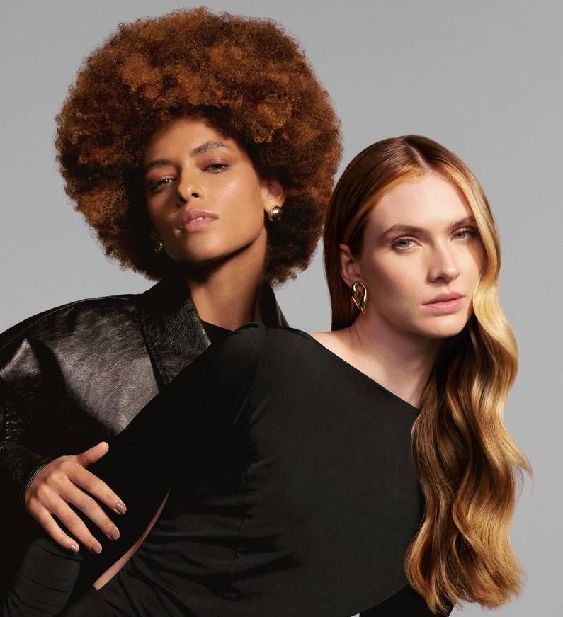 Dos mujeres posan para una foto y una tiene un afro