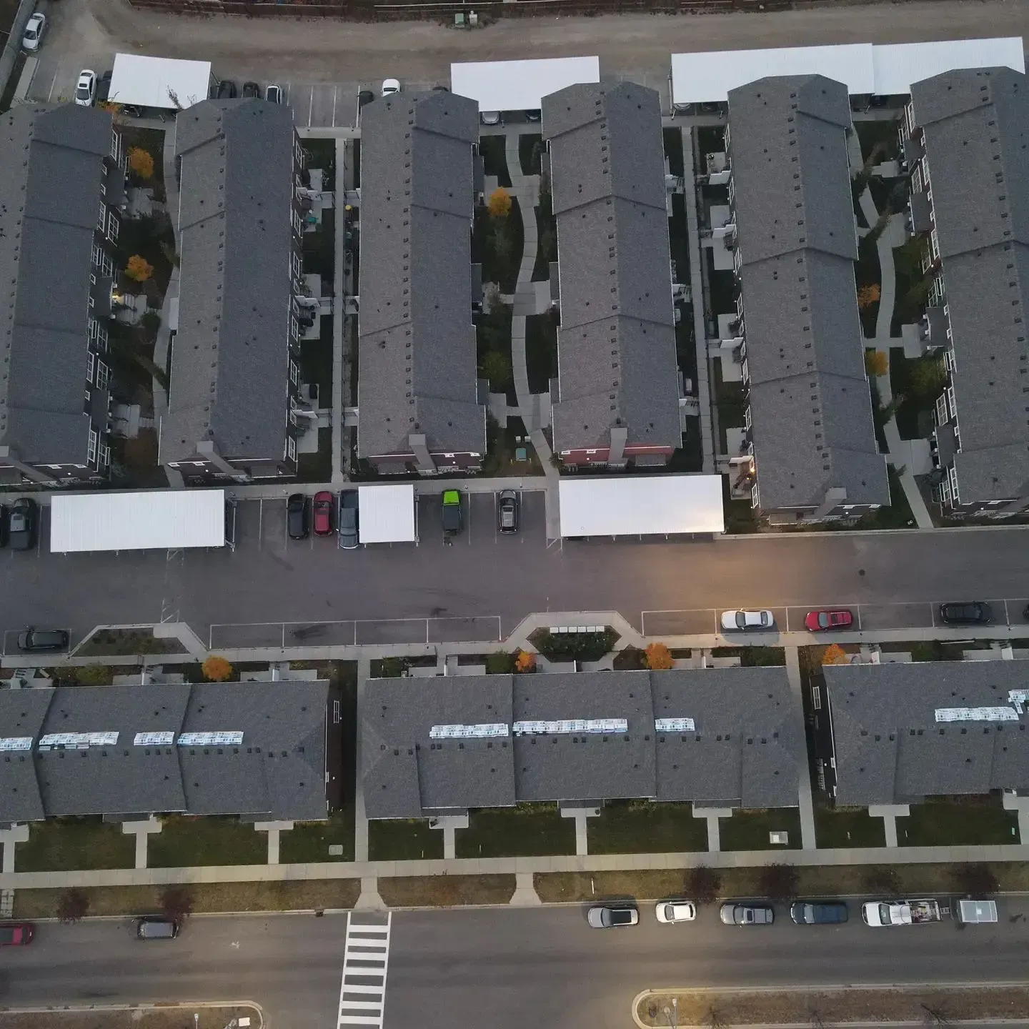 Aerial view of apartment buildings, parked cars, and streets in a residential neighborhood.