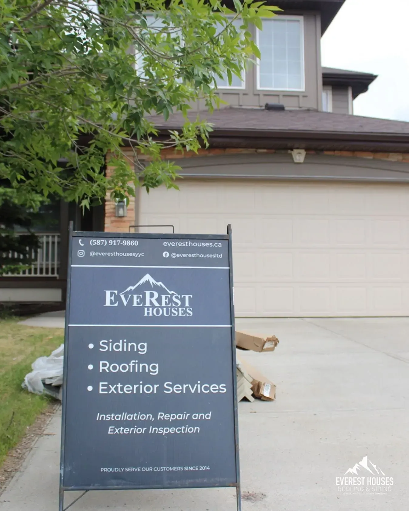 Everest House sign in front of a suburban home with a garage and trees