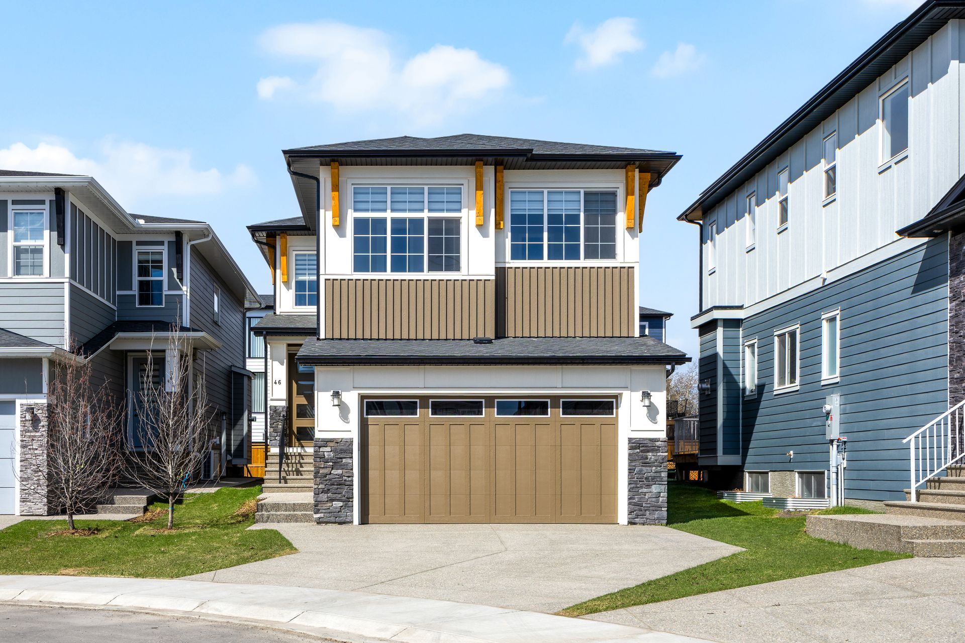Modern two-story suburban house with beige garage, wood accents, and neighboring homes on both sides