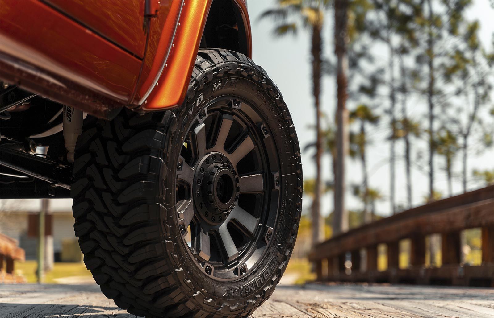 A close up of a truck 's tire on a dirt road