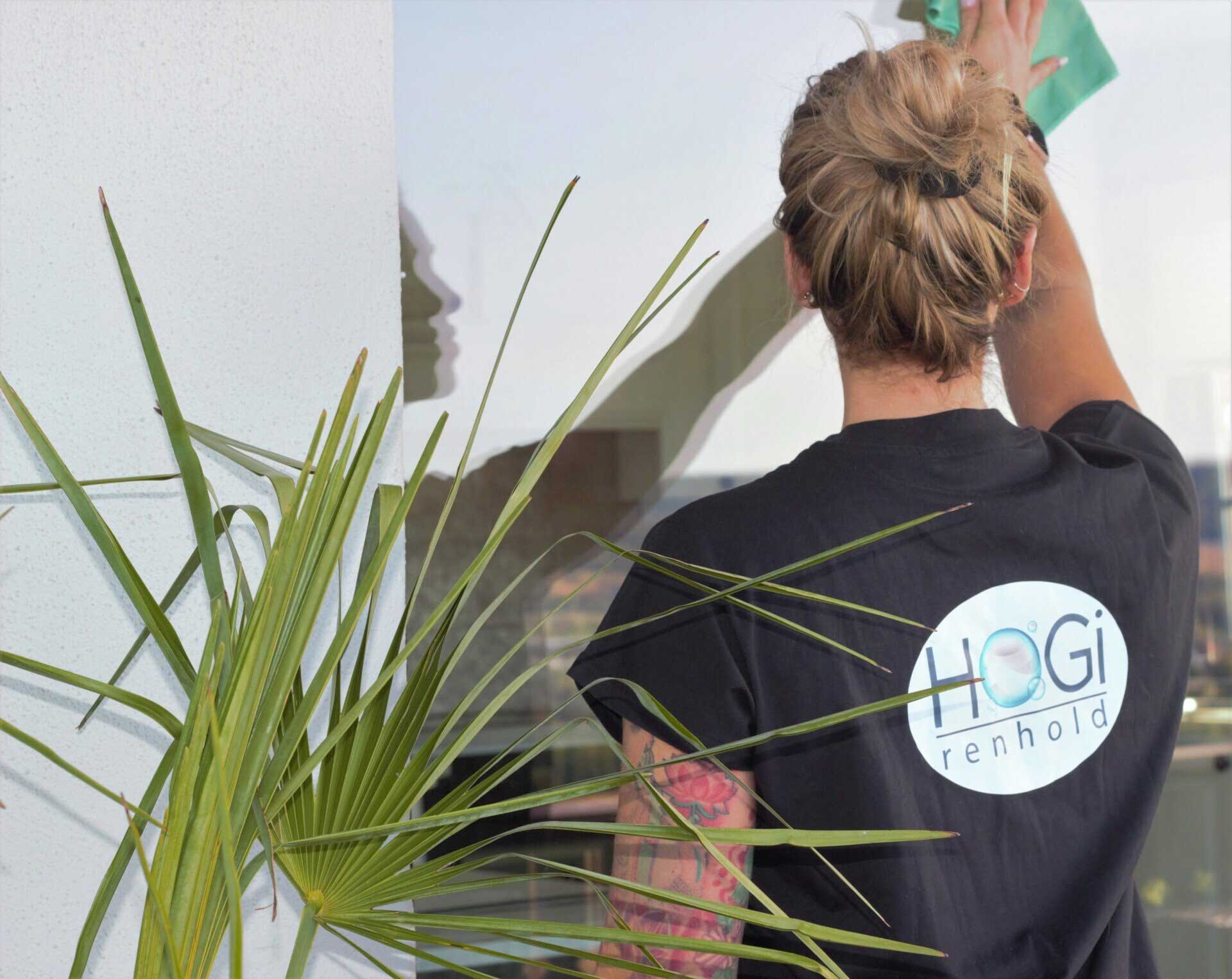 Renholder i HoGi Renhold som vasker vindu på et kontor