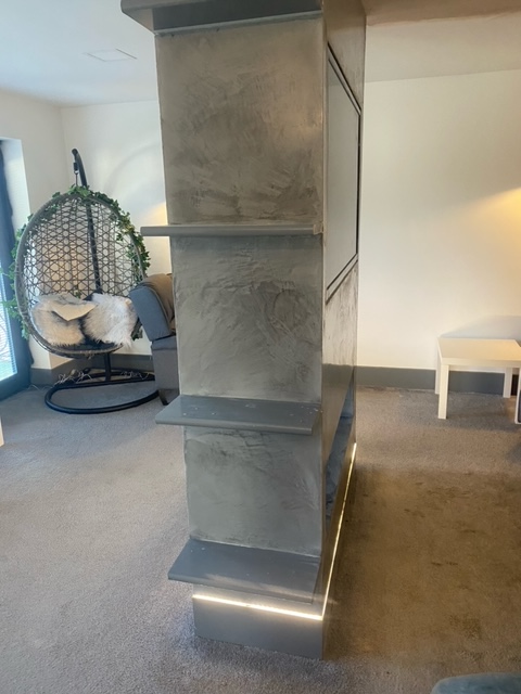 Concrete staircase with integrated lighting, leading downwards. A hanging chair sits below.