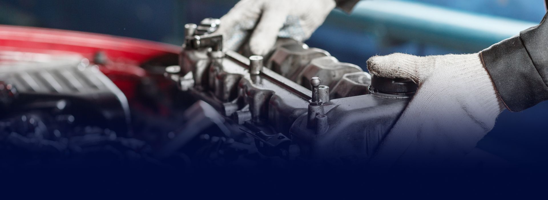 Mechanic's gloved hands working on an engine, likely repairing or assembling components. | Beach Auto Repair