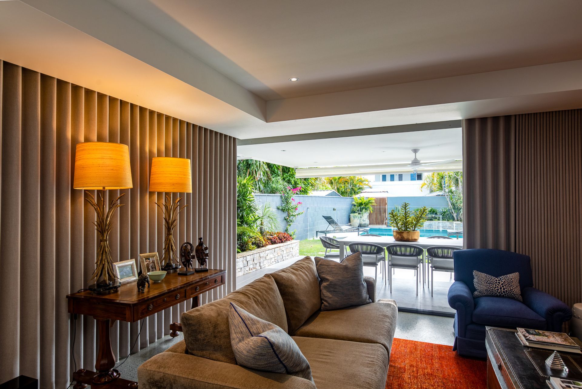 A living room with a couch , chair , table and lamps.