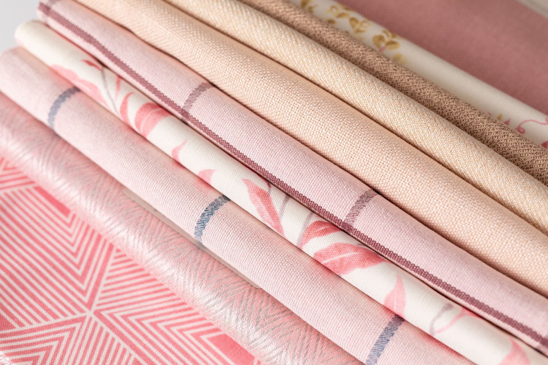 A close up of a stack of pink fabrics on a table.